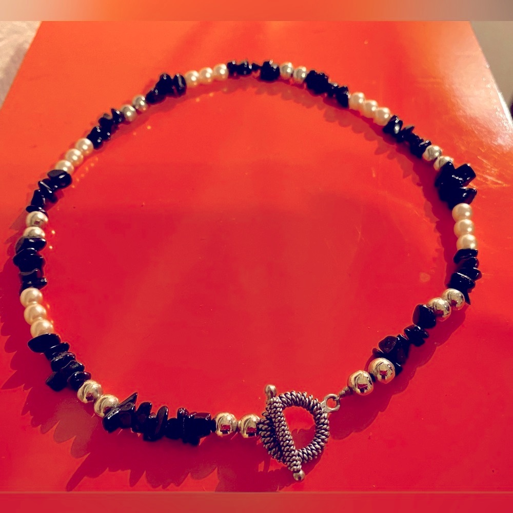 Onyx with pearl and silver slide accents. Toggle clasp. 16”